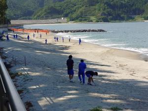 浜辺の清掃活動をする生徒たち